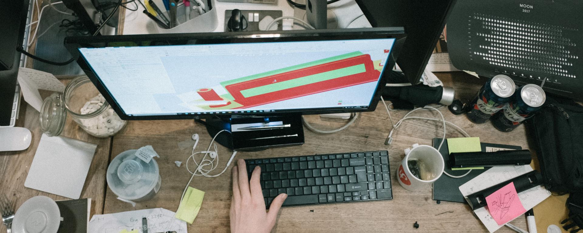 computer and keyboard on desk with many other items