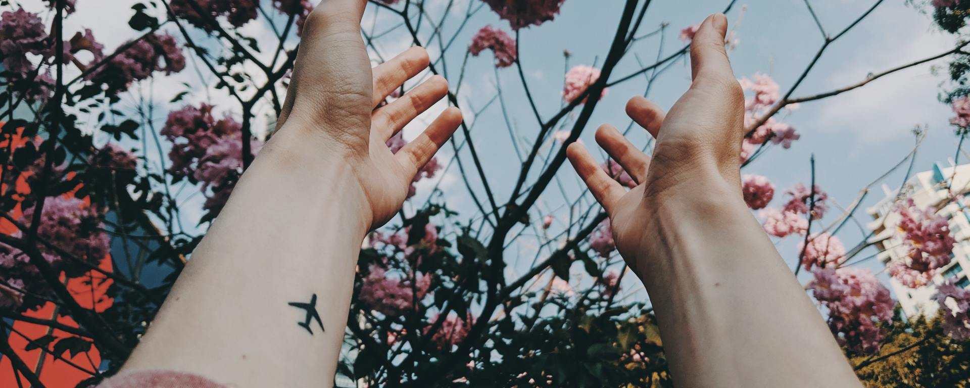 flowers and arms extended to the sky