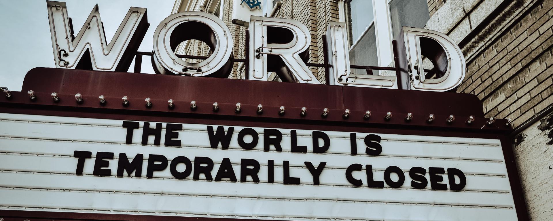 world theater marquee sign that reads "the world is temporarily closed"