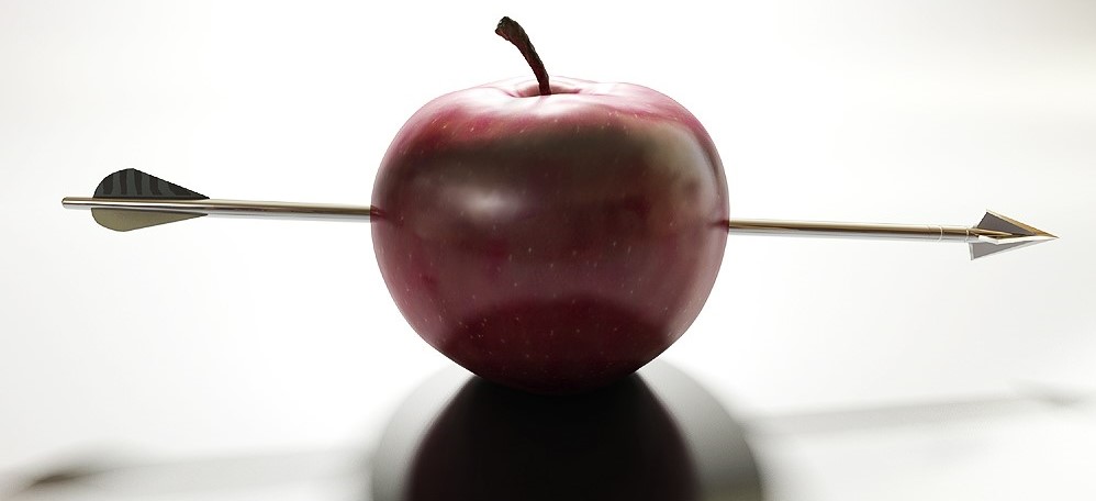 red apple sitting on white background with a metal arrow through the center