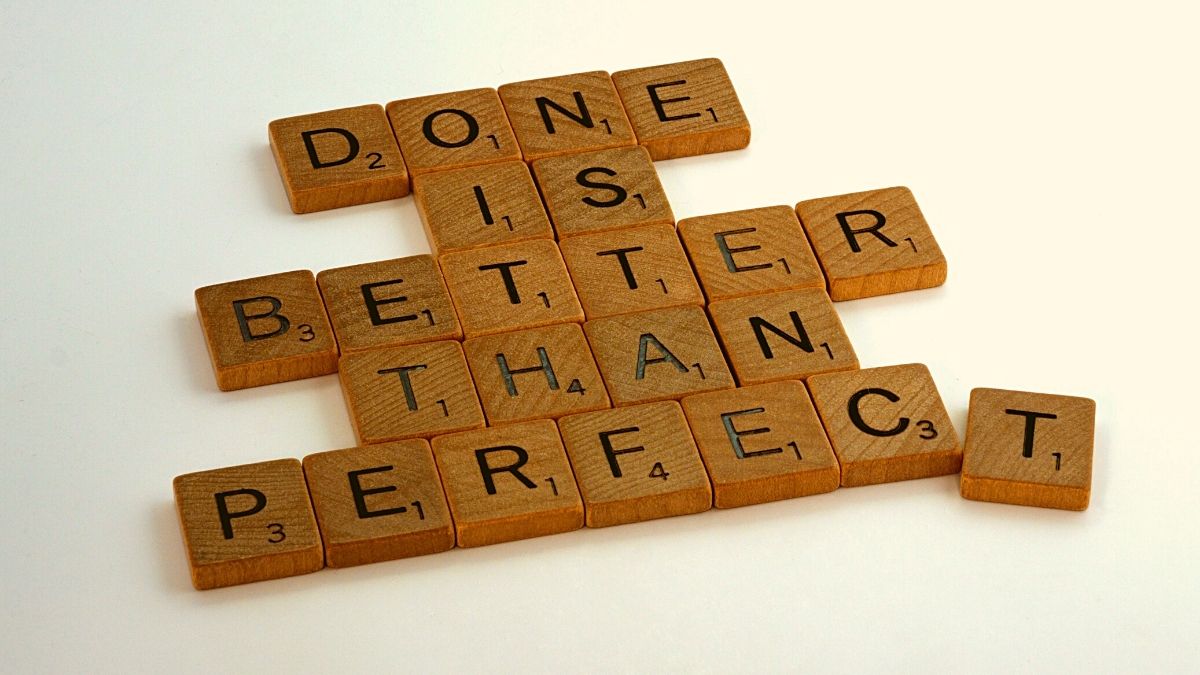 scrabble letters that read "done is better than perfect" on a white background