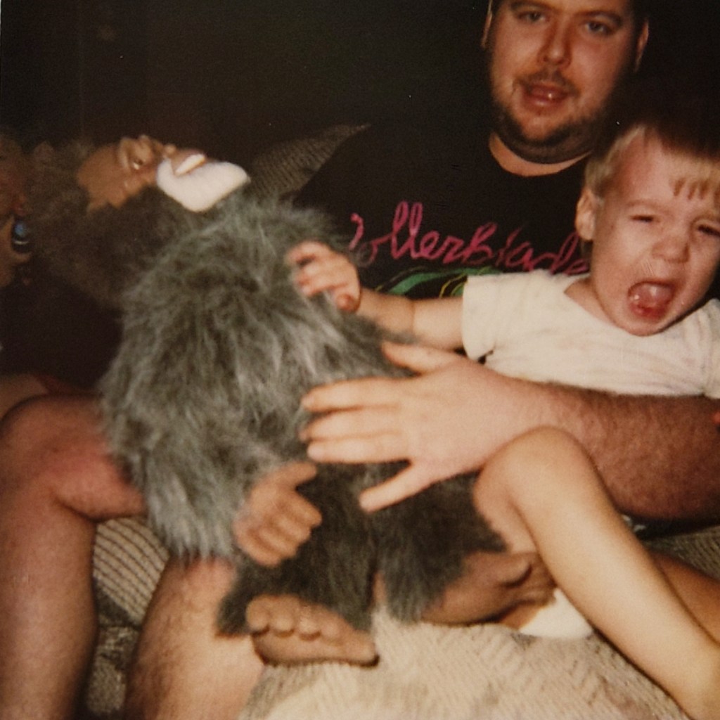 young dan crying while his dad holds him and the harry doll