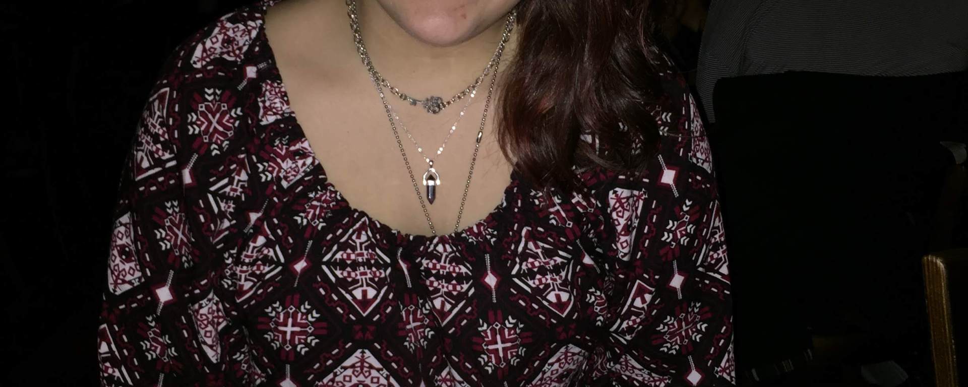 renata smiling in front of a plate with a lit candle