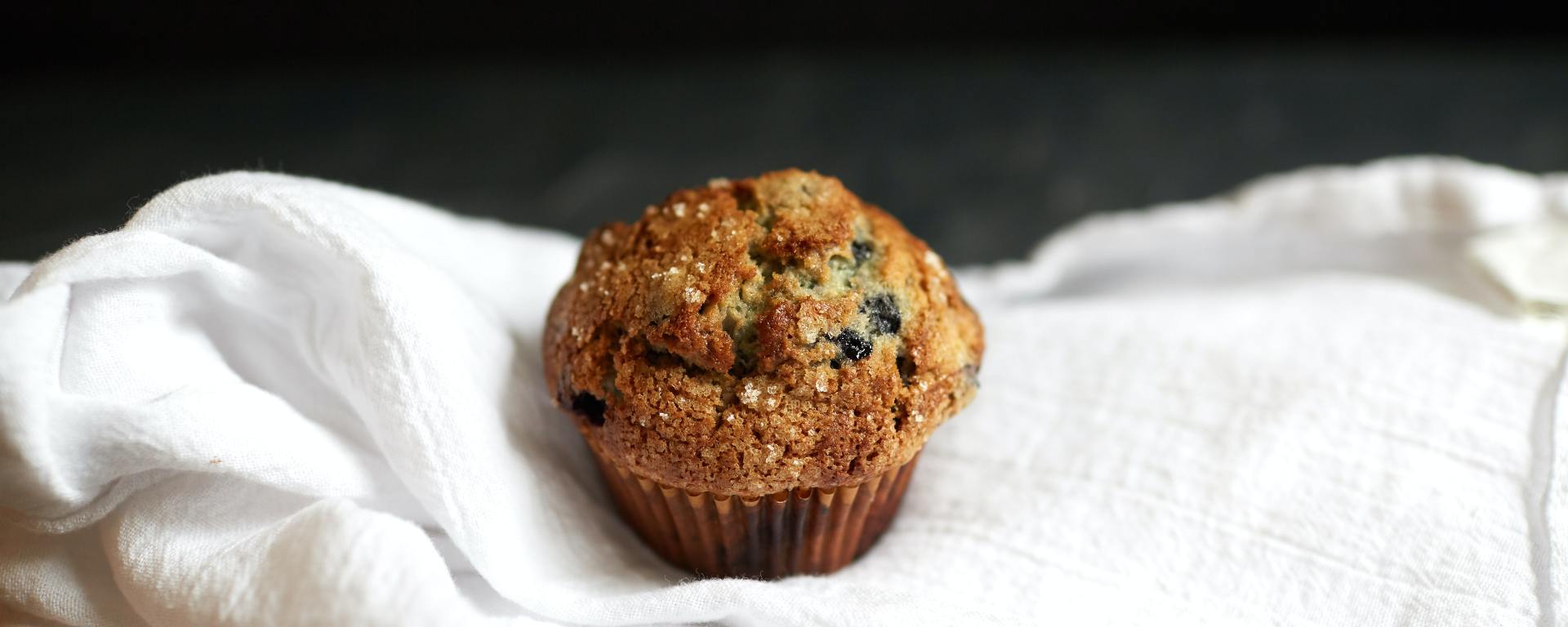 blueberry muffin sitting on a linen tablecloth