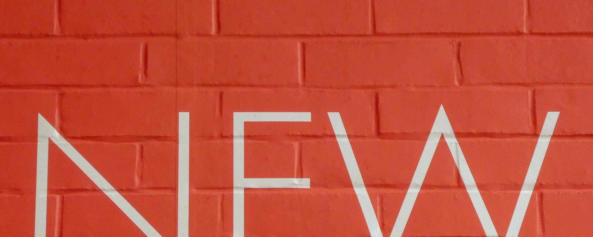 brick wall with the word "new" in white letters