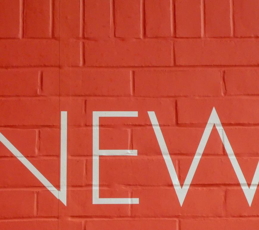 brick wall with the word "new" in white letters