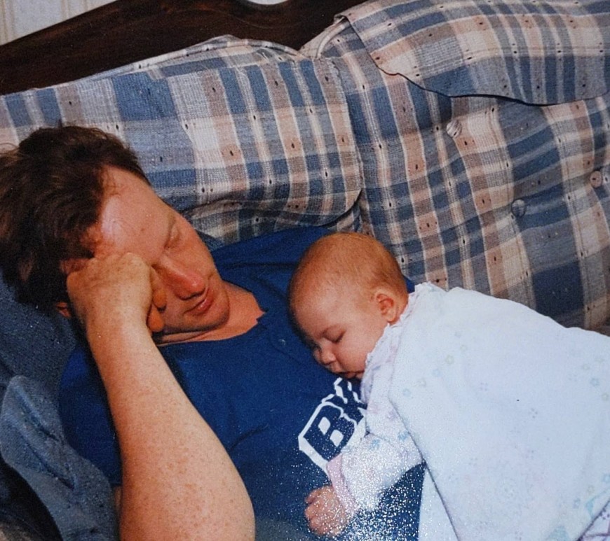 baby renata sleeping on her uncle johns chest while they lay on the couch