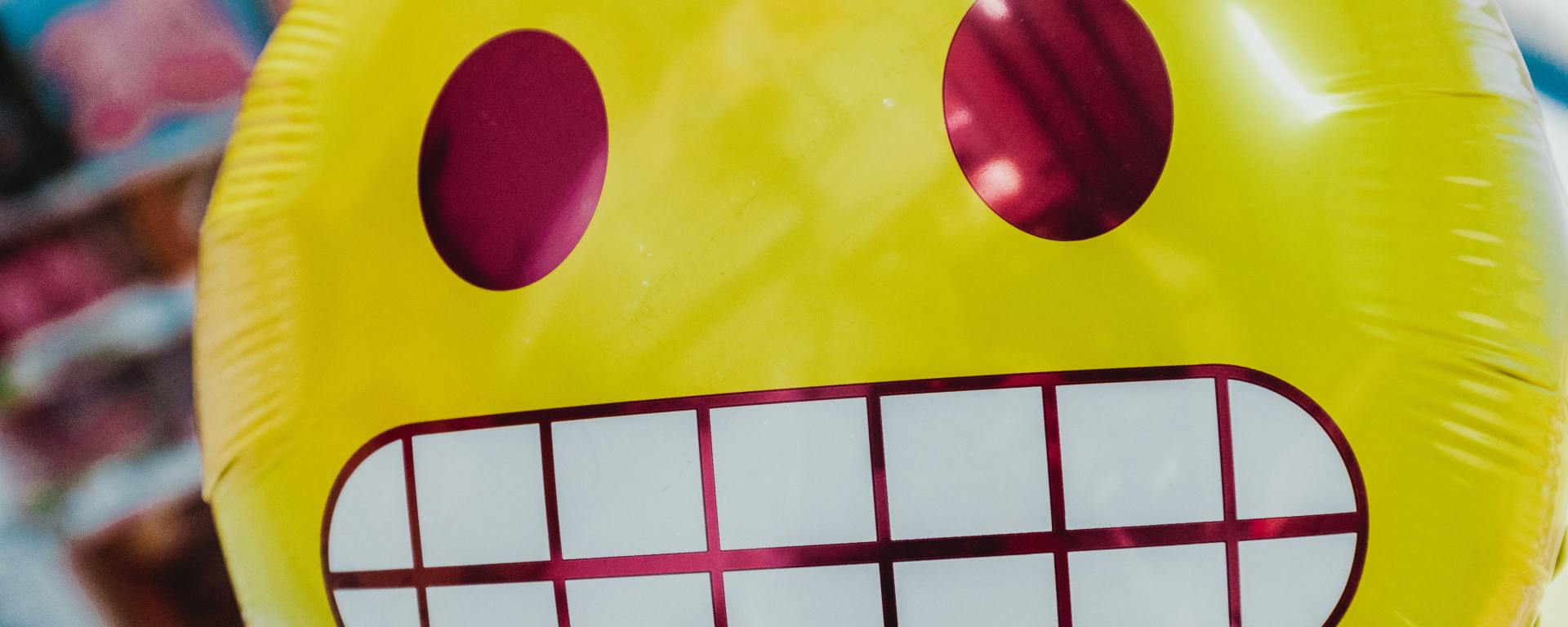 Mylar balloon of the grimacing emoji