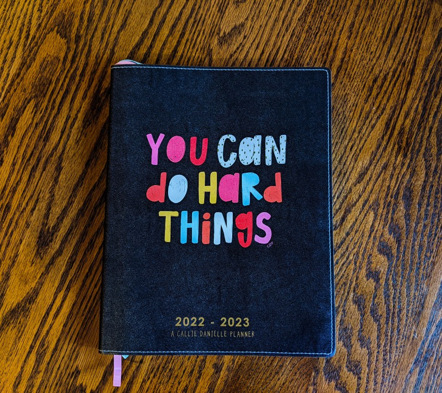 journal that says "you can do hard things" on a wood background