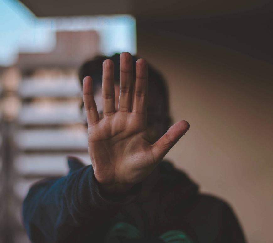 person holding hand up in front of camera as if to say "Stop"