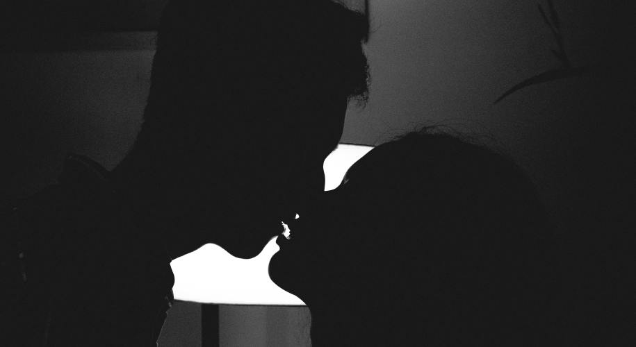 silhouette photo of man and woman kissing