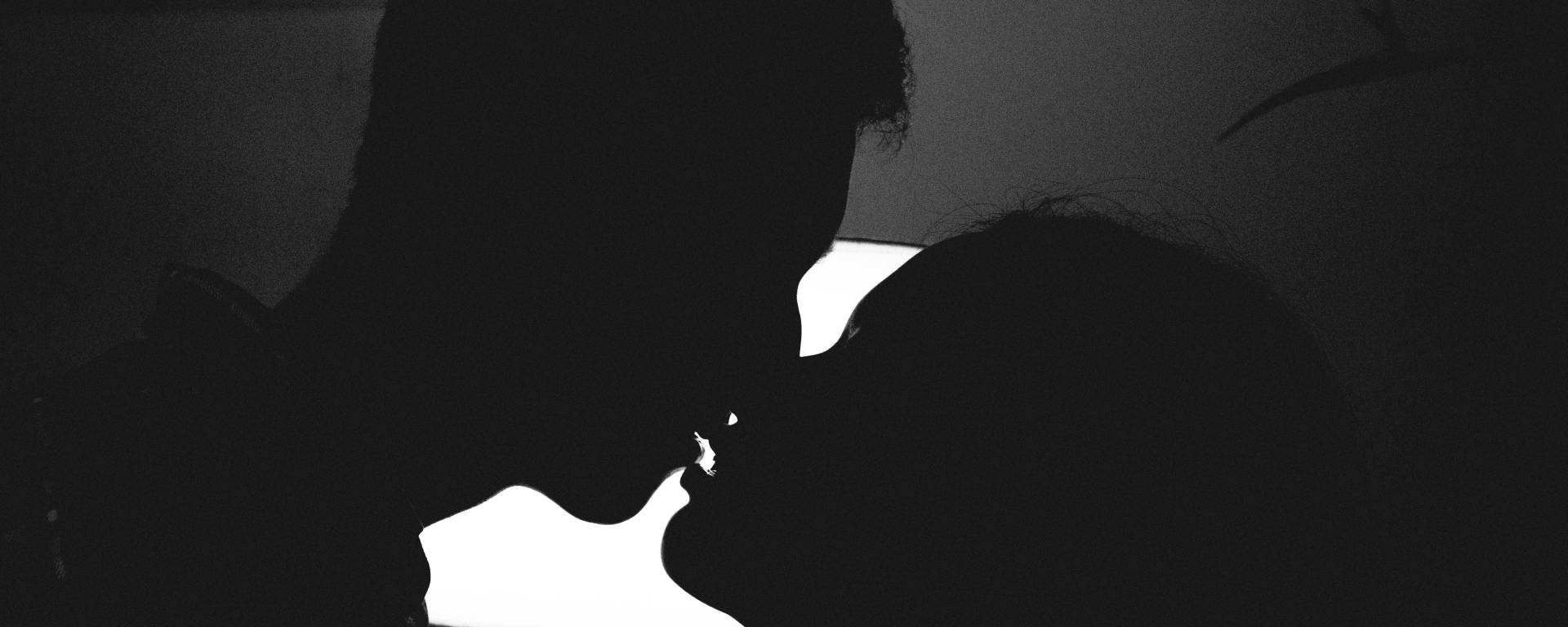silhouette photo of man and woman kissing